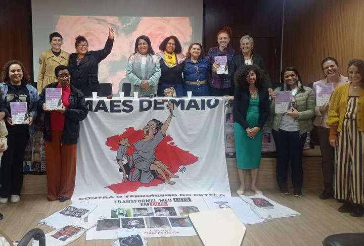 Women standing at publication launch event with banners